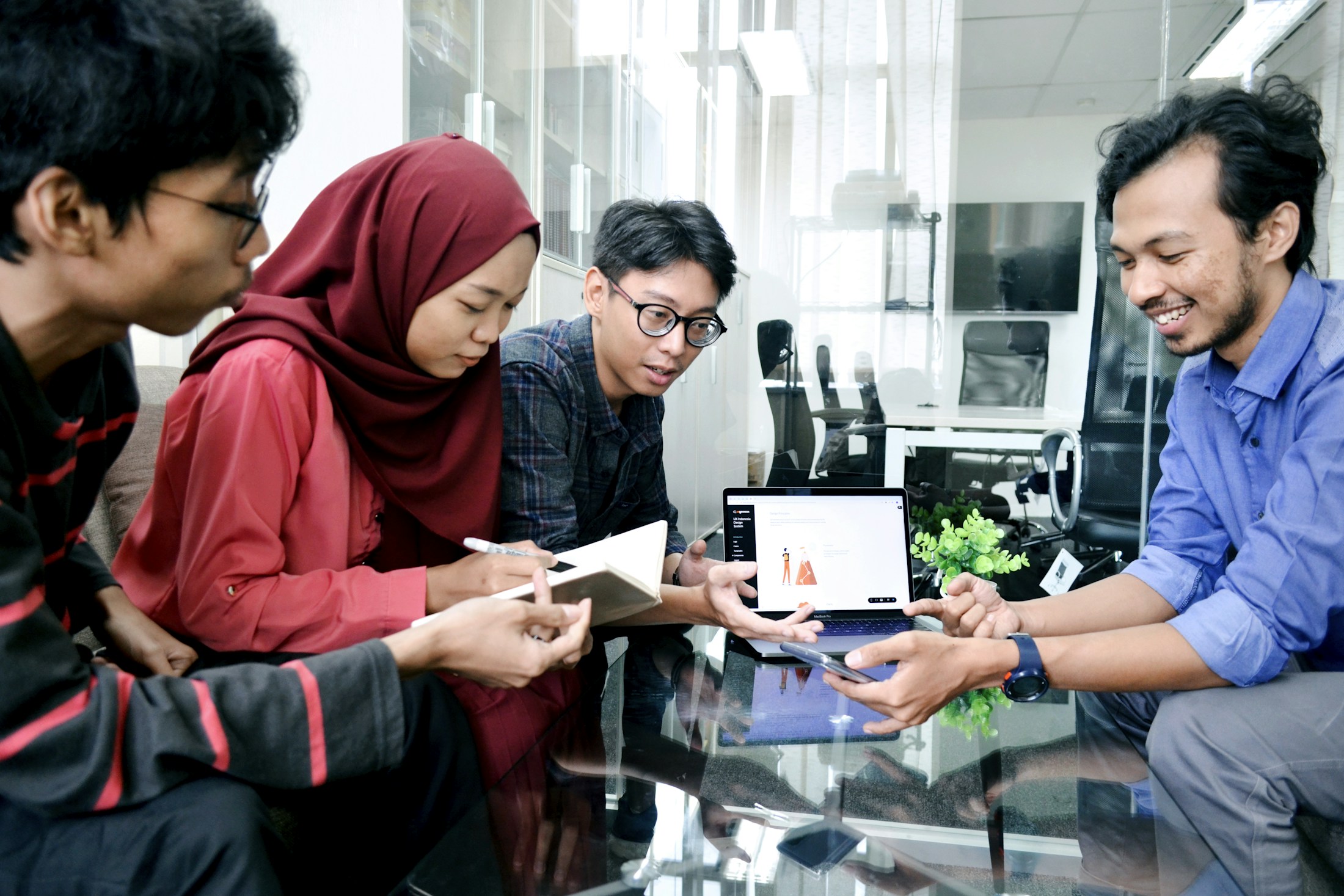 A group discussing work and reviewing materials at a table in Jakarta