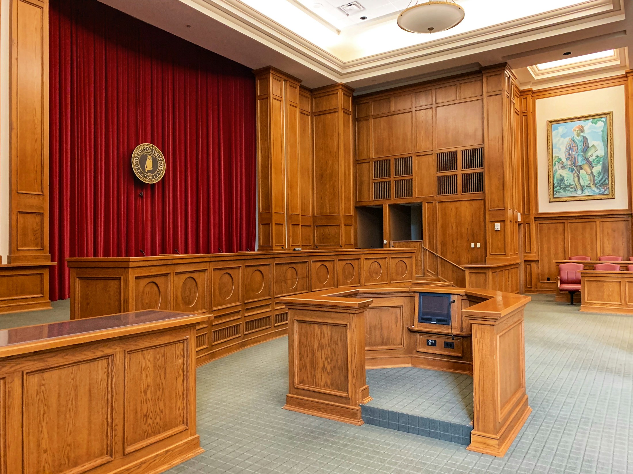A teaching courtroom with wooden benches and a counsel table