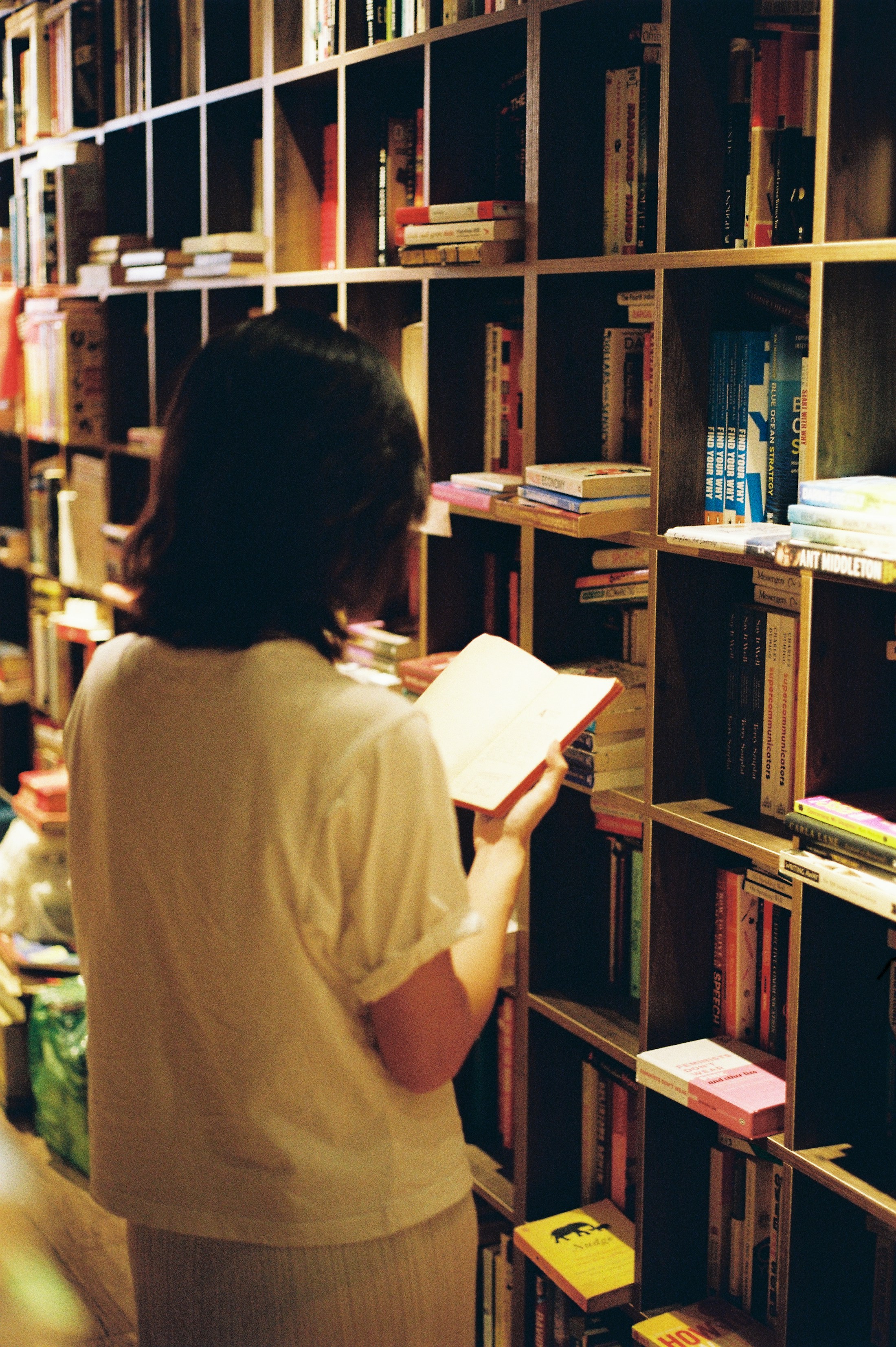 A person reading beside shelves of business and reference books